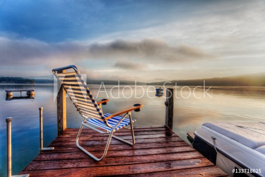 Picture of Chair sitting at the end of a dock in very early morning summer light